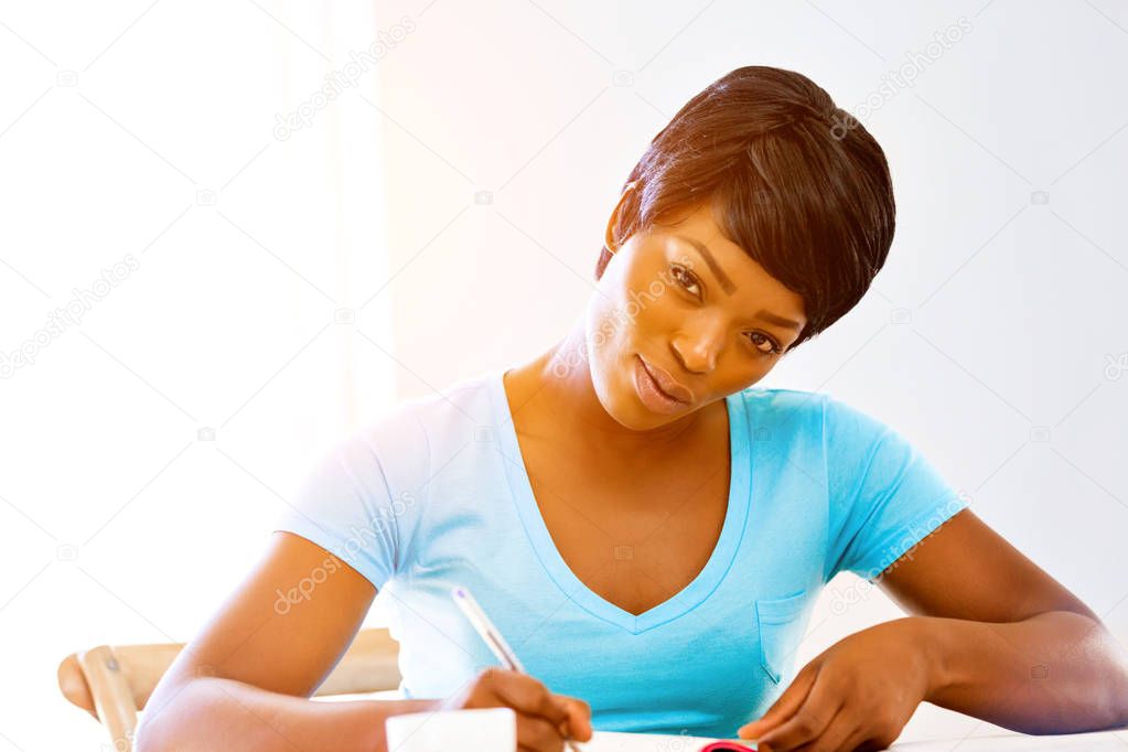 Young woman writing in an agenda at home or office