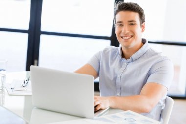 Bilgisayarda çalışan yakışıklı işadamı