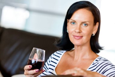 Kırmızı şarap ile cam tutan güzel genç kadın