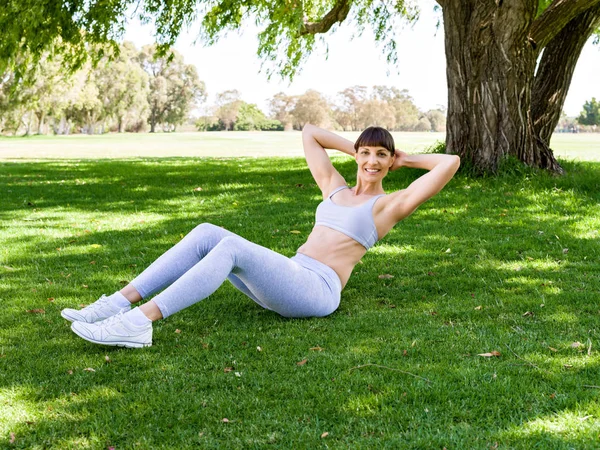 Mujer joven haciendo ejercicio en el parque — Foto de Stock