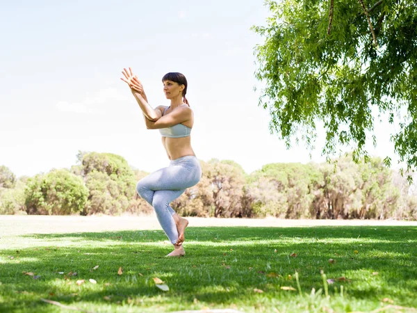 Mujer joven practicando yoga en el parque — Foto de Stock