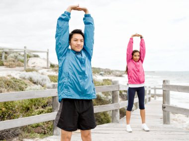 Egzersizleri yapıyor deniz kenarında genç Çift