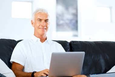 Adam evde dizüstü bilgisayarla çalışıyor.