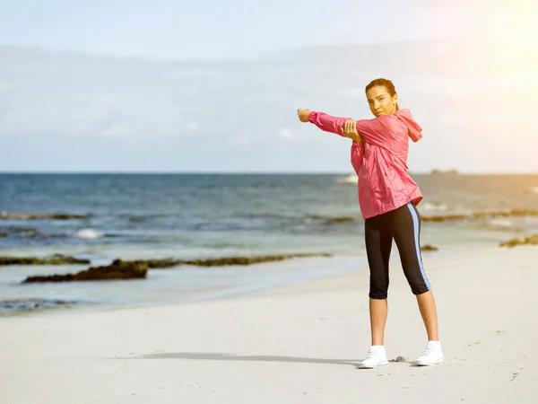 Молодая женщина на пляже делает упражнения — стоковое фото