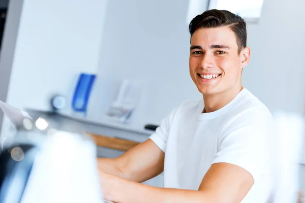 Jeune homme avec des papiers dans leur salon — Photo