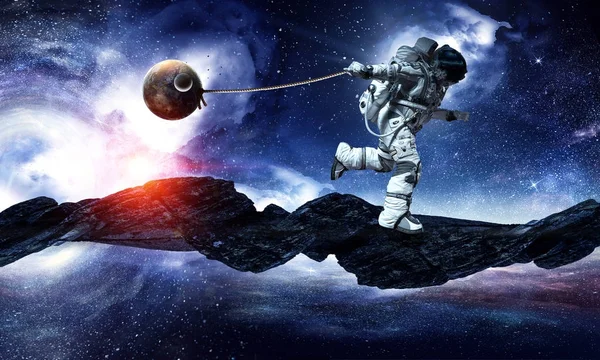 Imagem de fantasia com astronauta pegar planeta. Meios mistos — Fotografia de Stock