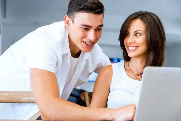 Feliz pareja moderna trabajando en el ordenador portátil en casa —  Fotos de Stock
