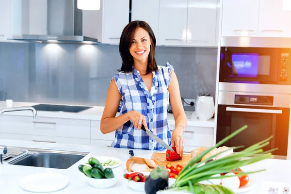 Mulher bonita de pé na cozinha e sorrindo — Fotografia de Stock