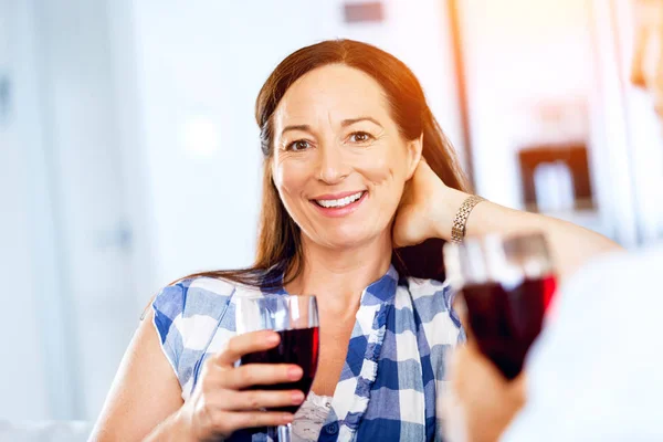 Donna con in mano un bicchiere di vino in casa — Foto Stock