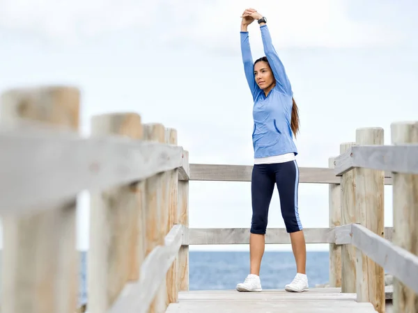 Mladá žena na pláži dělá cvičení — Stock fotografie