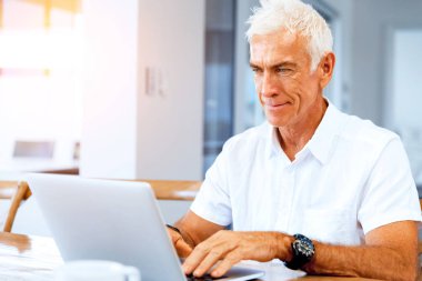 Adam evde dizüstü bilgisayarla çalışıyor.