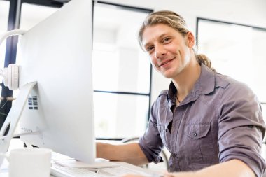 Bilgisayarda çalışan yakışıklı işadamı