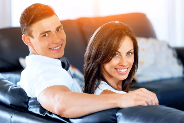 Young couple looking at camera while sitting at home — Stock Photo, Image