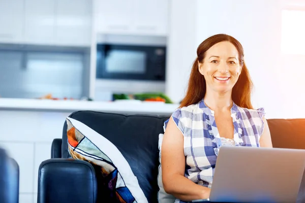 Reife schöne Frau arbeitet auf ihrem Laptop — Stockfoto