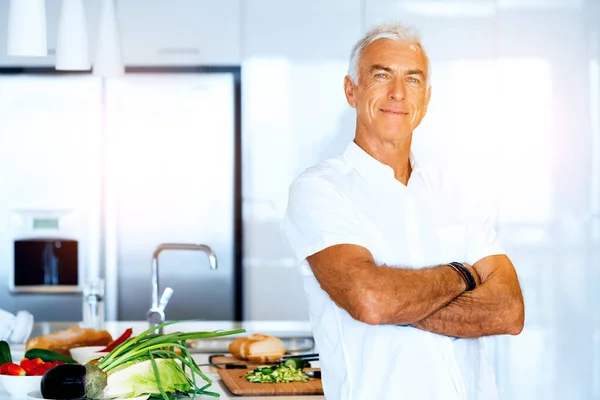 Portrait of a smart senior man standing in kitchen — Stock Photo, Image