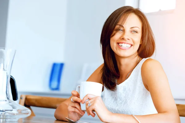 Mujer joven feliz con taza de té o café en casa —  Fotos de Stock