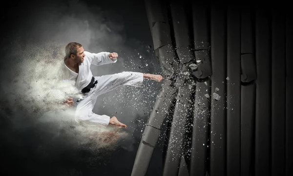 Mann im Kimono bricht Mauer. Gemischte Medien — Stockfoto