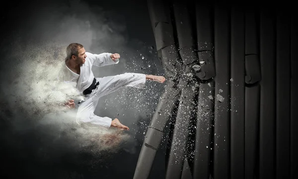 Un homme en kimono brise le mur. Techniques mixtes — Photo