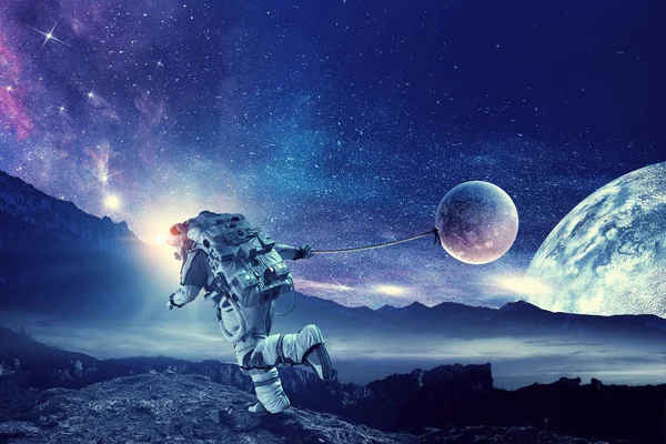 Fantasie afbeelding met spaceman vangst planeet. Mixed media — Stockfoto