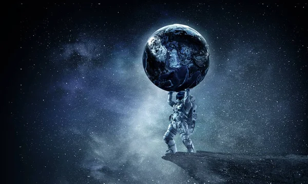 L'homme de l'espace porte une grande planète. Techniques mixtes — Photo