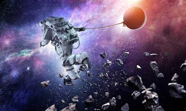 Fantasie afbeelding met spaceman vangst planeet. Mixed media — Stockfoto