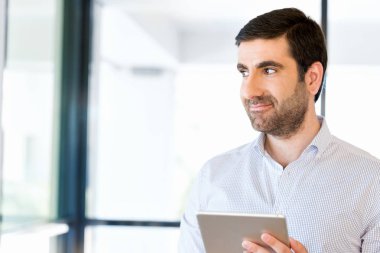 Genç yakışıklı işadamı onun touchpad ayakta kullanma office