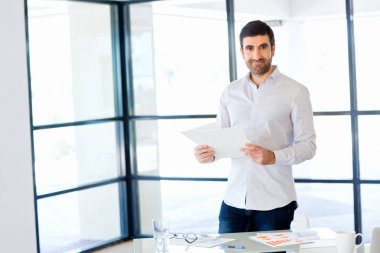 Ofiste duran genç beyaz iş adamı