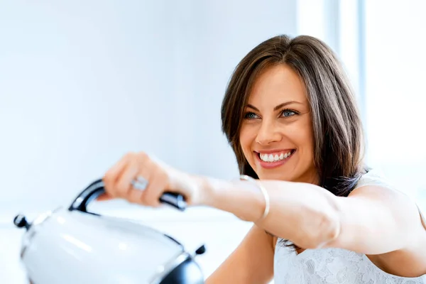 Gelukkig jonge vrouw met een kopje thee of koffie thuis — Stockfoto