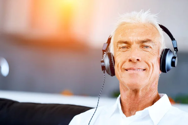 Schöner grauhaariger älterer Mann mit Kopfhörern — Stockfoto