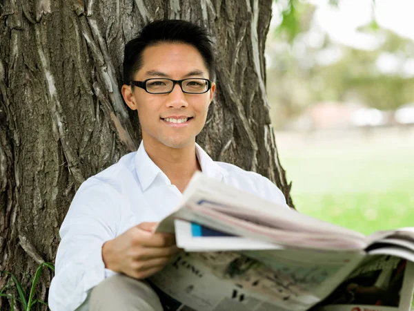 ビジネスの男性が公園で新聞を読む — ストック写真