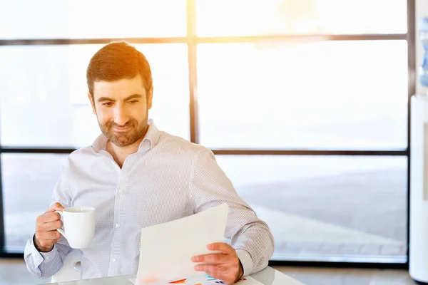 Knappe jonge man houden van papier in kantoor — Stockfoto