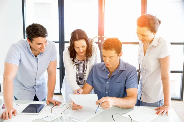 Groep van gelukkige jonge zakenmensen in een vergadering — Stockfoto