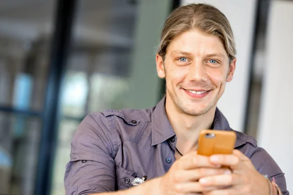 Confident young man in smart casual wear holding phone — Stock Photo, Image