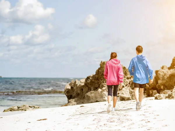 Молода пара біжить уздовж берега моря — стокове фото