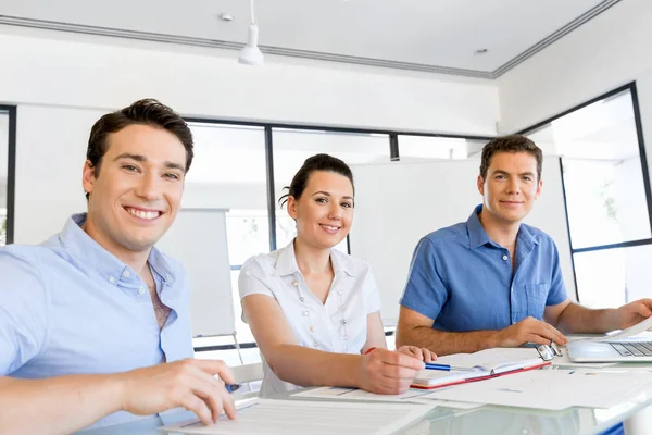 Groep van gelukkige jonge zakenmensen in een vergadering — Stockfoto