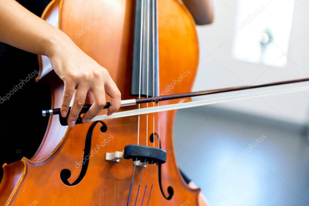 Close up of cello with bow in hands