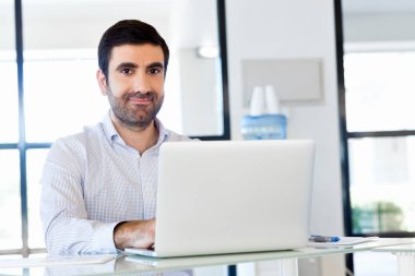 Bilgisayarda çalışan yakışıklı işadamı