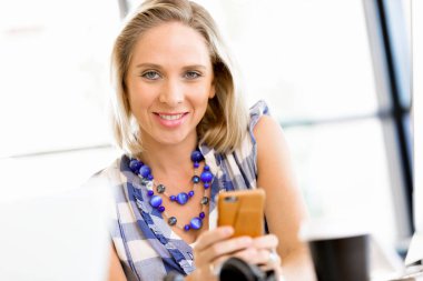 iş kadını ofiste cep telefonu ile