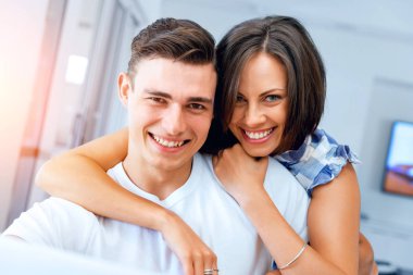 Kameraya gülümseyen mutlu çift