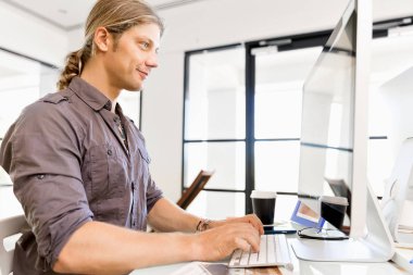 Bilgisayarda çalışan yakışıklı işadamı