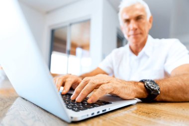 Adam evde dizüstü bilgisayarla çalışıyor.