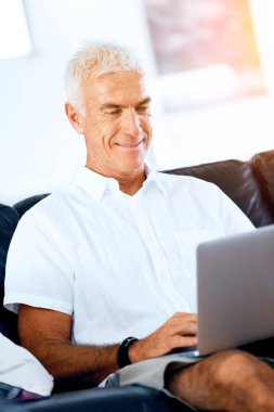 Adam evde dizüstü bilgisayarla çalışıyor.