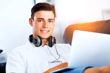 Adam evde dizüstü bilgisayarla çalışıyor.