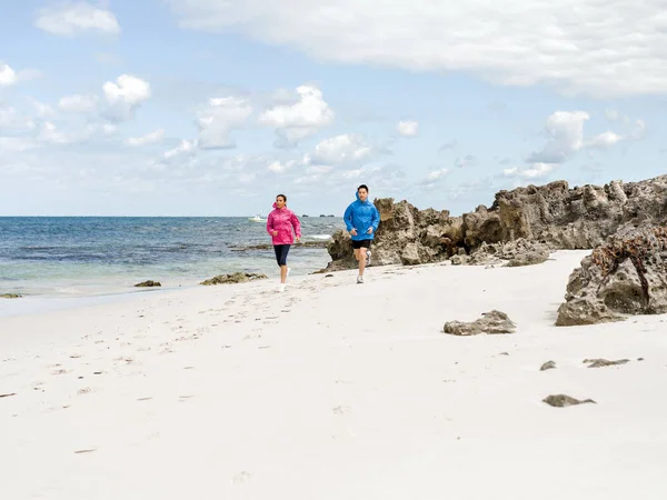 年轻夫妇沿着海边跑 — 图库照片