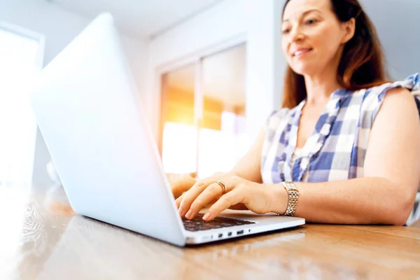 Reife schöne Frau arbeitet auf ihrem Laptop — Stockfoto