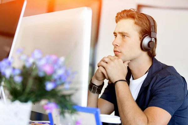 Jeune homme dans le bureau avec écouteurs — Photo