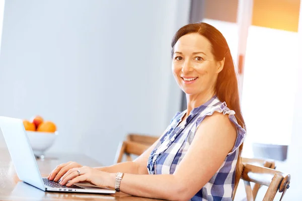 Rijpe mooie vrouw die op haar laptop werkt — Stockfoto