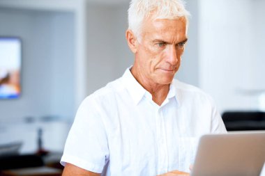 Adam evde dizüstü bilgisayarla çalışıyor.