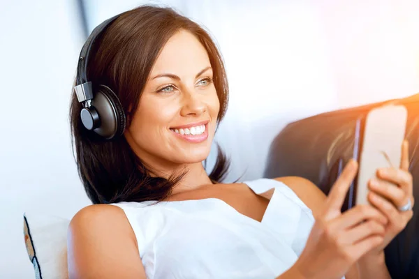 Mujer joven con auriculares sentados en casa — Foto de Stock