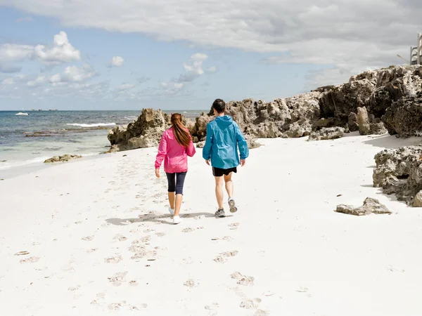 Unga par kör längs havsstranden — Stockfoto